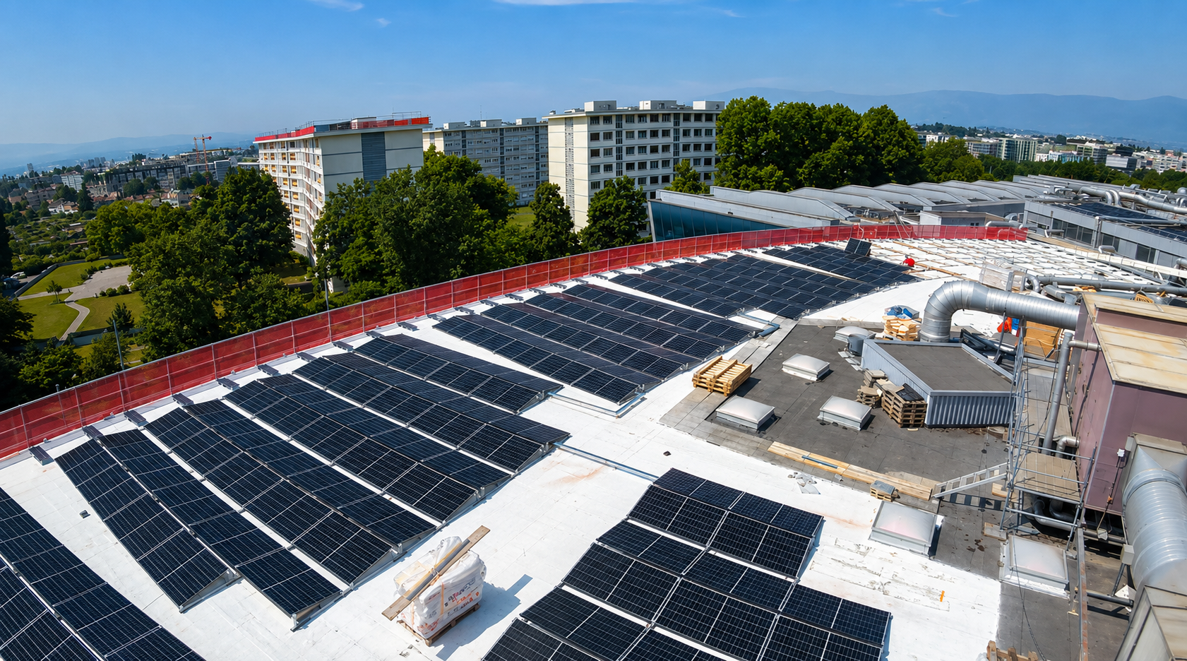 Installation en cours de panneaux solaires sur un toit en sheds d’un bâtiment industriel en rénovation, pour une production locale d’électricité verte.