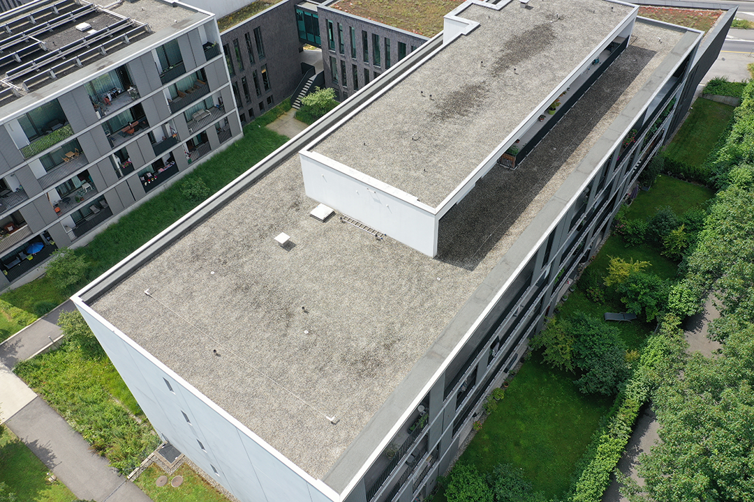 Photo aérienne de l’immeuble résidentiel à Meyrin avant le commencement des travaux d’installation solaire.