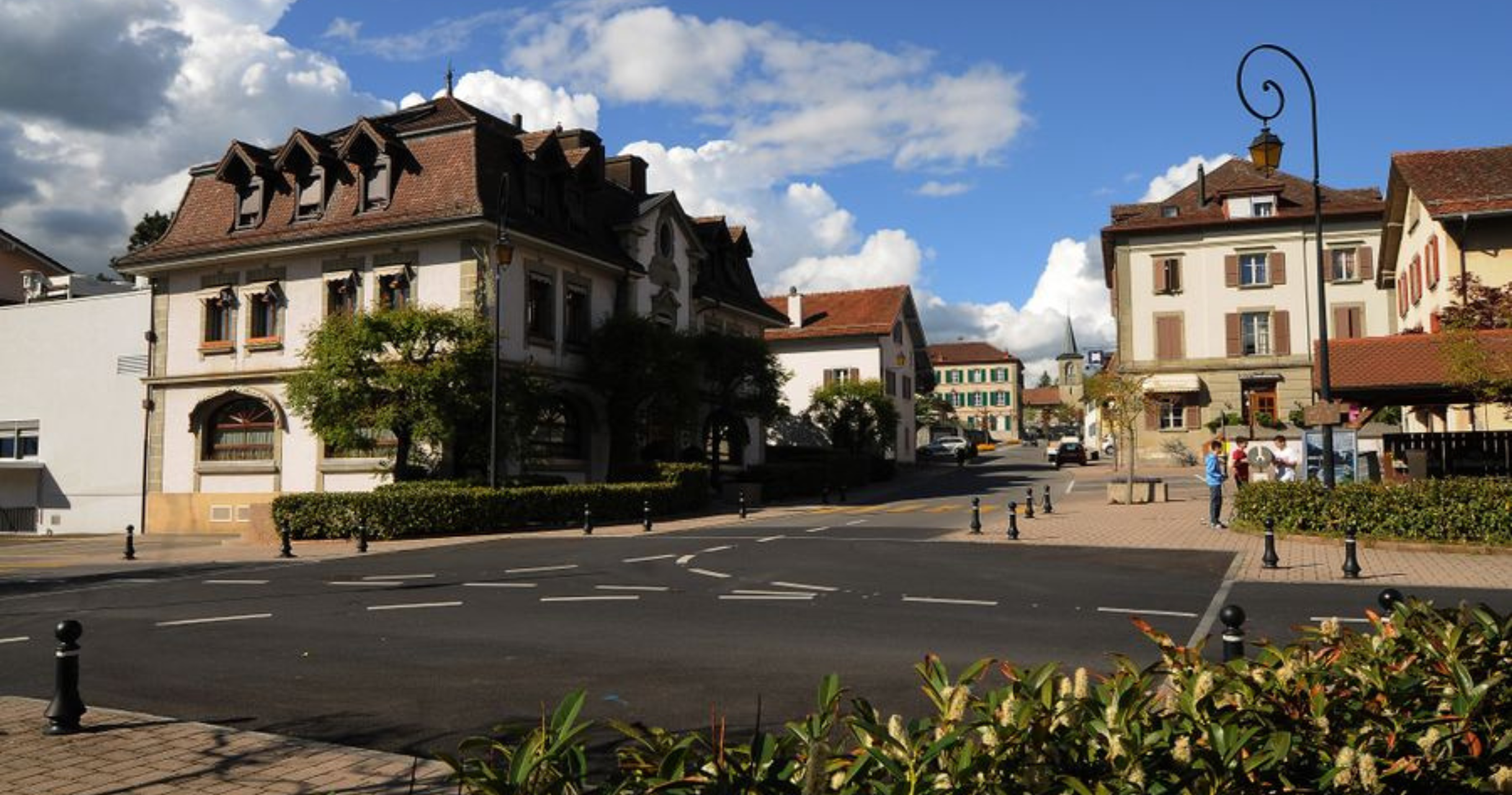Centre-ville de Crissier (canton de Vaud) avec ses bâtiments communaux et la place principale sous un ciel bleu, illustrant un cadre idéal pour des projets solaires photovoltaïques.