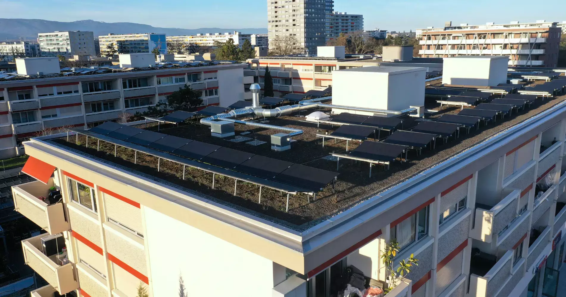 Vue aérienne rapprochée des panneaux photovoltaïques sur un des bâtiments.