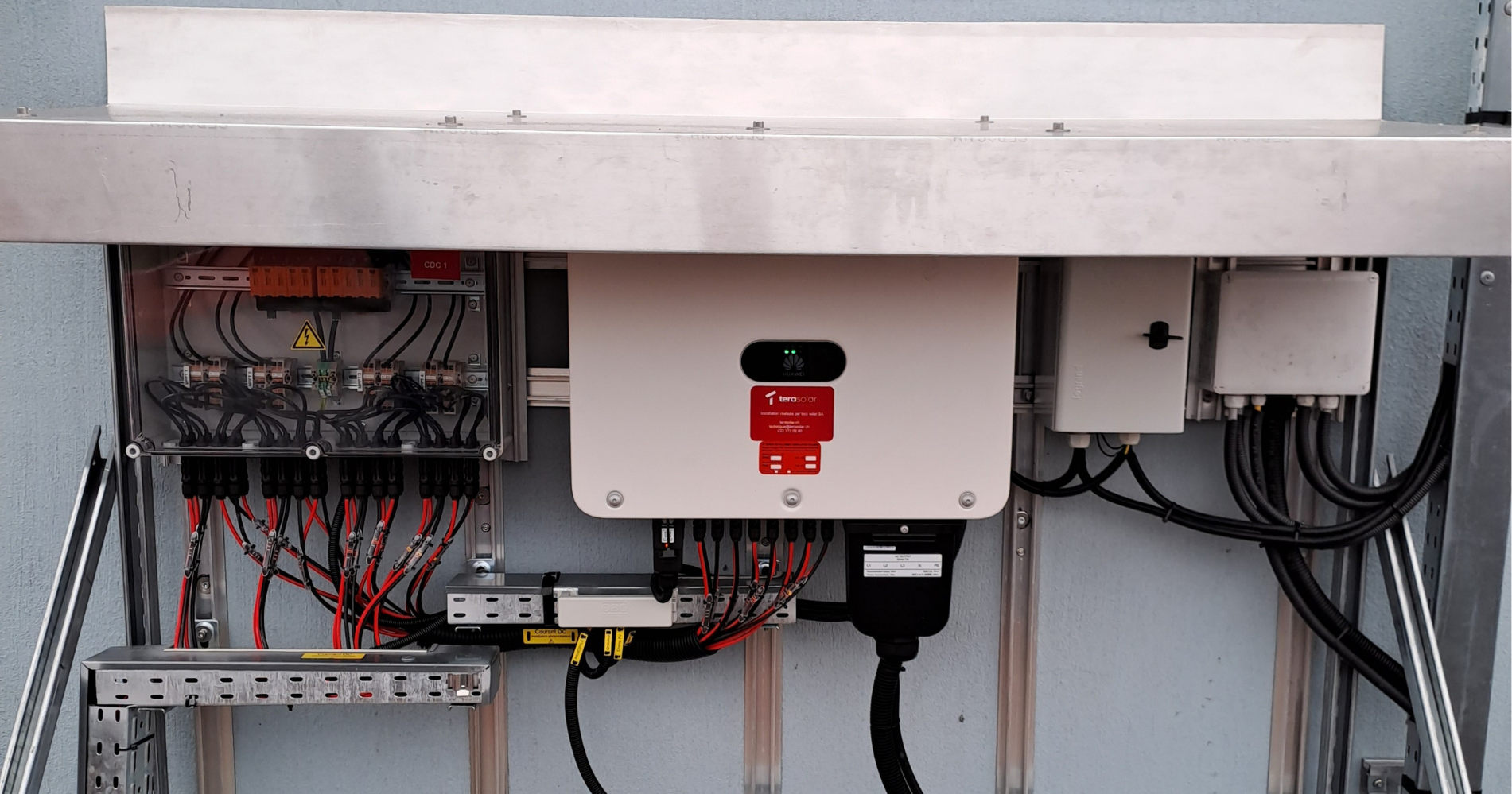 Onduleur photovoltaïque installé et raccordé au réseau électrique, assurant la conversion du courant continu en courant alternatif.