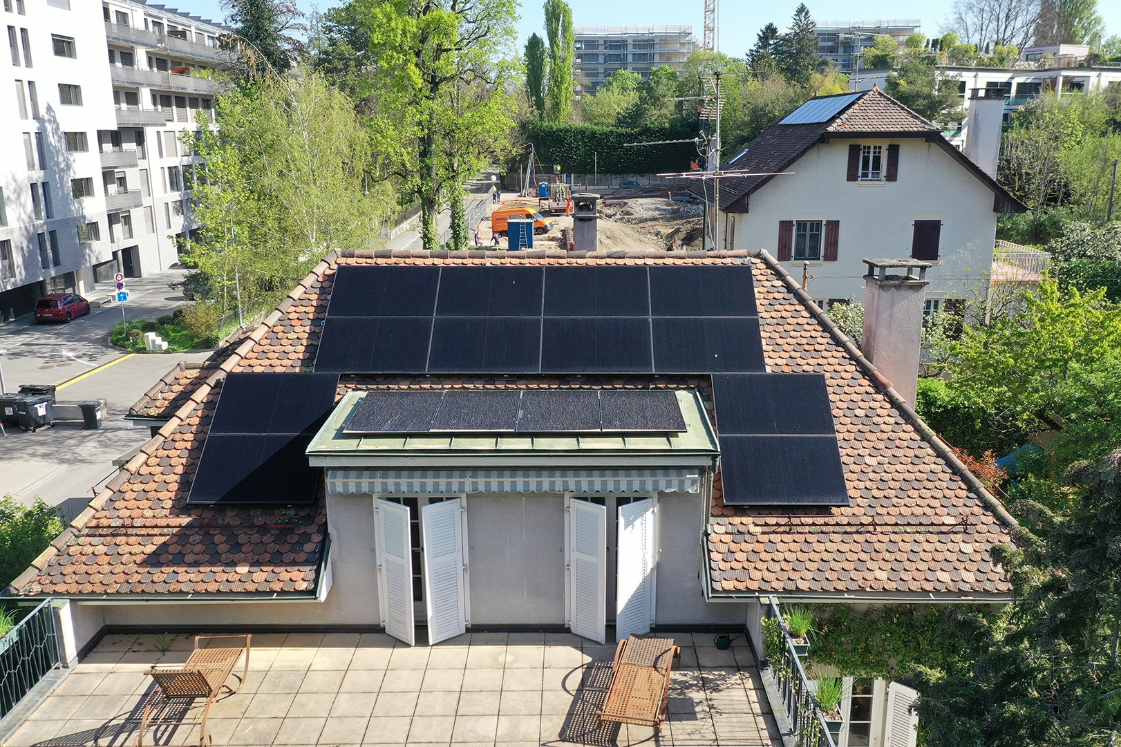 Vue drone d'une maison équipée de panneaux solaires sur toiture, intégration harmonieuse et production d'énergie renouvelable.