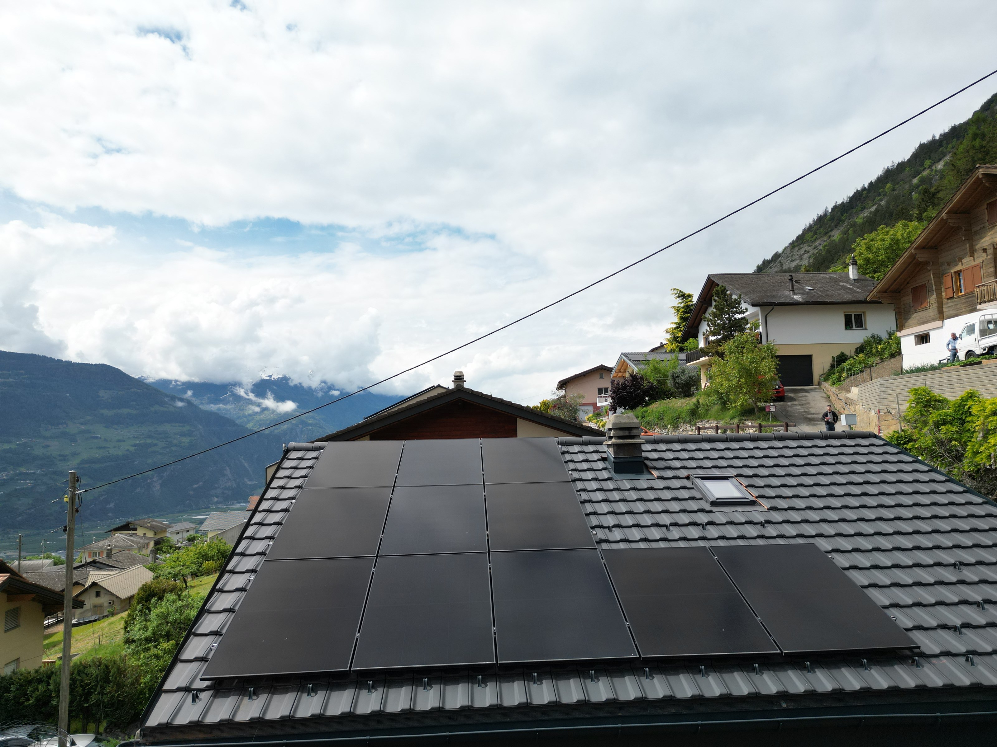 Maison familiale à toit en pente à Anières avec antennes TV, avant l'installation de panneaux solaires.