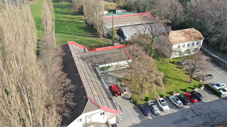 Photo aérienne de deux toitures avec panneaux solaires en cours d’installation pour le Golf, illustrant l’avancement des travaux photovoltaïques