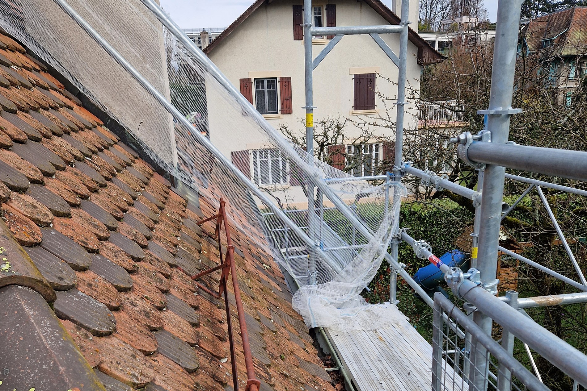 Installation de panneaux solaires sur toiture avec échafaudage sécurisé pour travaux en hauteur, début de chantier photovoltaïque.